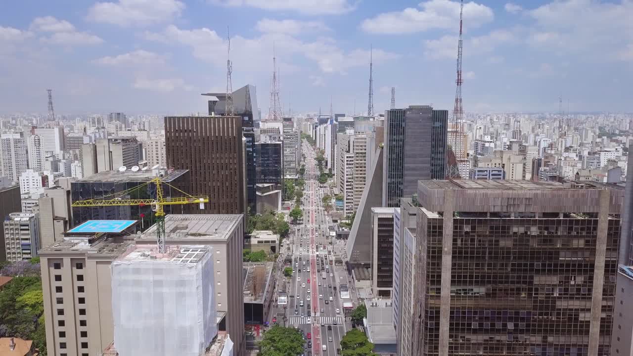 São Paulo, Brasil, e a principal rua comercial Avenida Paulista em um movimentado e ensolarado dia de verão - tomada aérea reveladora de edifícios e ruas