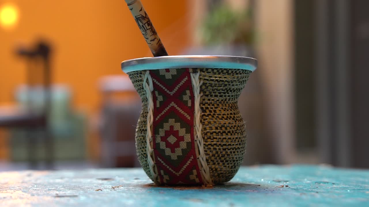verter agua caliente en una taza de té mate argentino con diseño tradicional