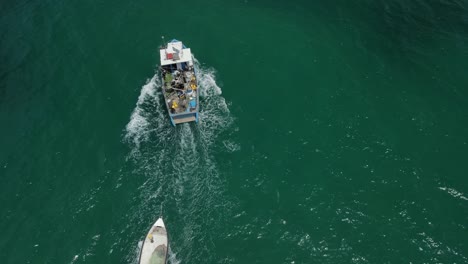 drone following a fishing boat pulling the skiff along as it moves into the haifa bay off hof hacarmel