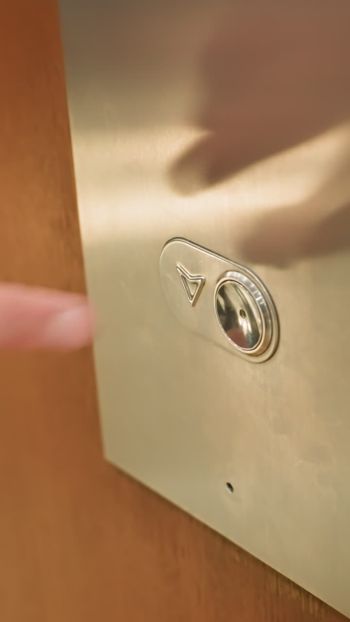 vista en primera persona capturada con una cámara portátil que muestra el dedo de una persona presionando el botón del ascensor. el primer plano destaca el momento de la interacción con el panel del ascensor