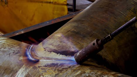 ingeniero masculino que utiliza una máquina de soplador de fuego en el taller 4k