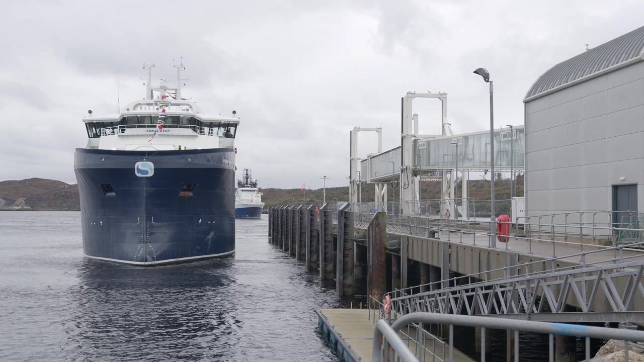 Static shot of a large boat docking into a harbour. Shot near Stornoway on the Isle of Lewis, part of the Outer Hebrides of Scotland.