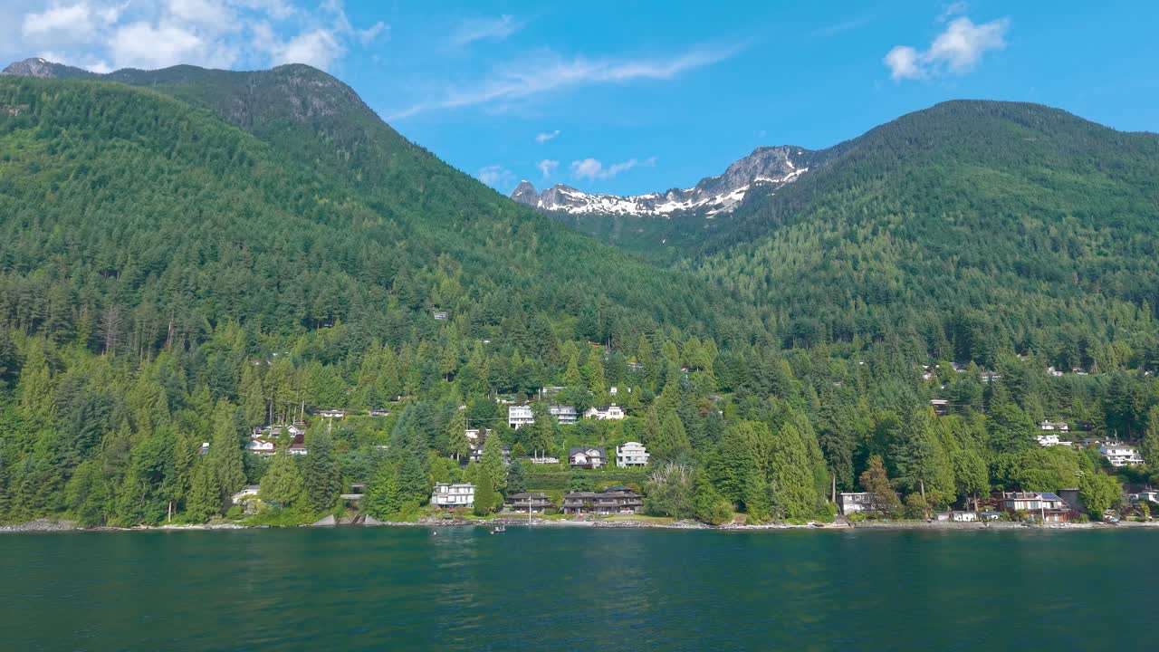 an aerial drone shot Luxury home on the coast of Lions bay coastline with the Brunswick Mountain on background