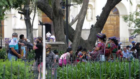 antigua guatemala many street vendor women gather around the main local town's plaza to sell different kinds of souvenirs and colorful handmade fabrics to tourists - handheld slow motion