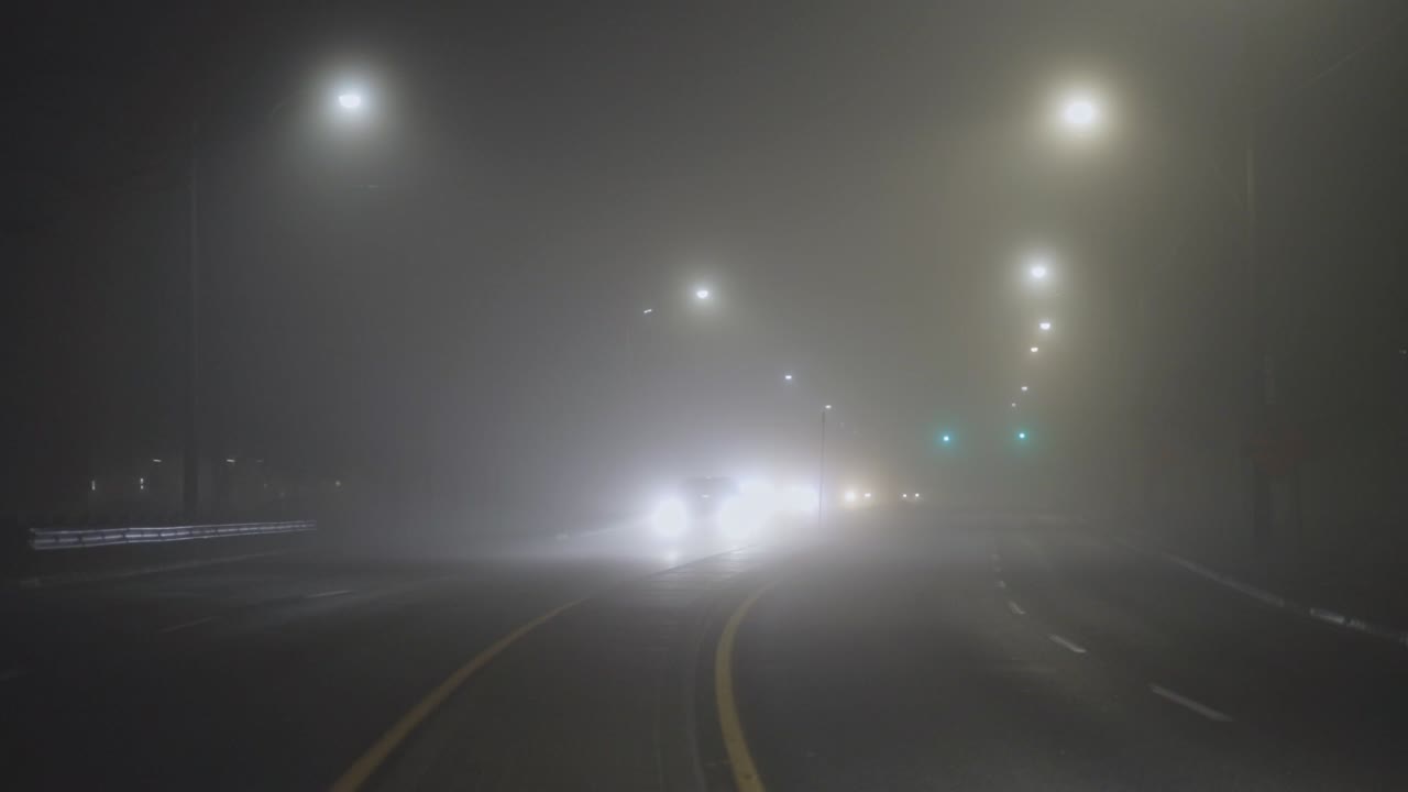 안개 낀 밤에 자동차가 고속도로를 달린다