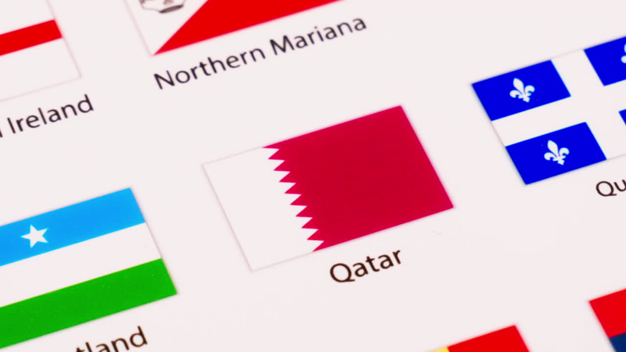 Primo piano della bandiera del Qatar che si allontana con lo zoom per mostrare il resto delle diverse bandiere nell'immagine