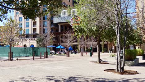 American-town-market-square-with-people-sitting-under-sun-umbrellas-parasols