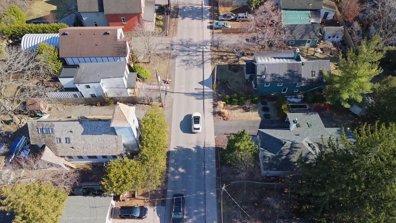 drone shot of a car driving in a residential neighborhood