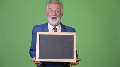 hombre de negocios barbudo y guapo contra un fondo verde.