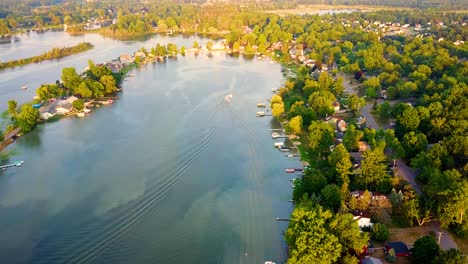 Drone-flight-over-a-lake,-with-footage-of-a-boat-towing-a-skier