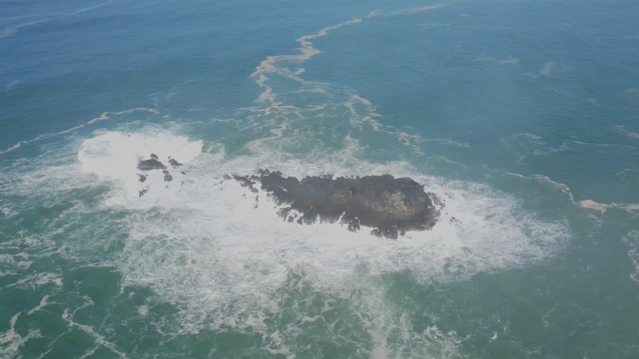 vista aérea de rocas de coral golpeadas por poderosas olas marinas