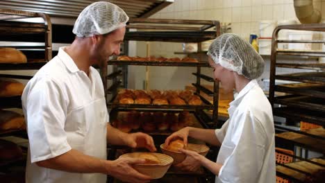 bakers putting baked michetta in basket