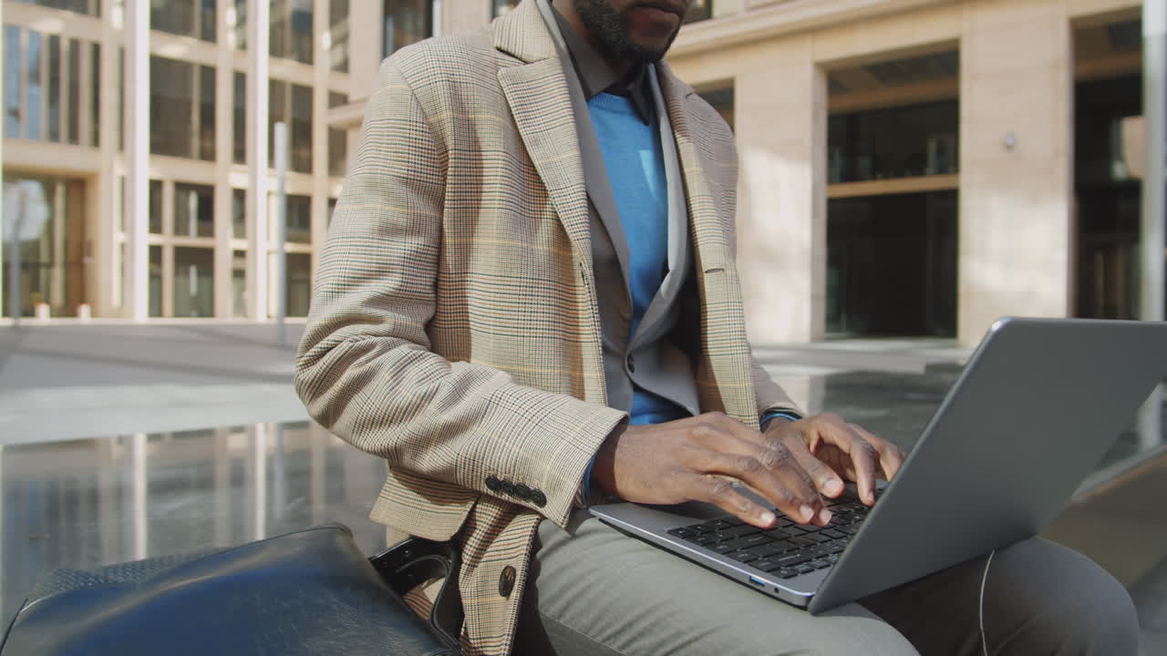 Black Businessman Working on Laptop Outdoors