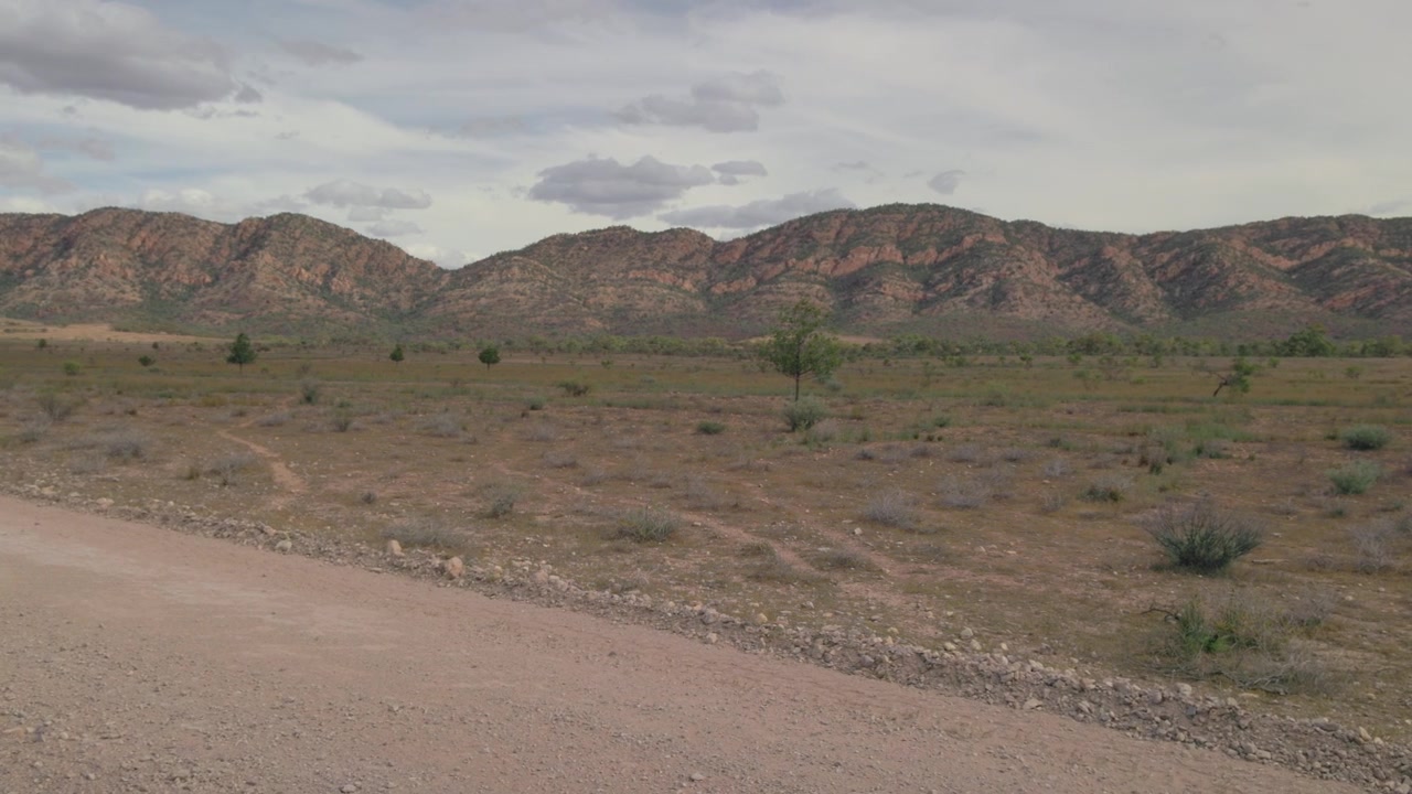 Lenta panoramica da una strada sterrata verso le montagne rosse nelle Flinders Ranges in Australia