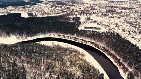 a winding river near a small town with a forest massif
