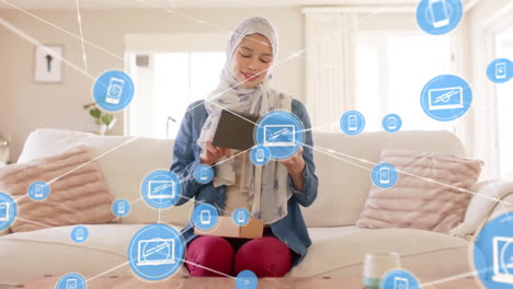 animation of globe with network of connections over biracial woman in hijab using tablet