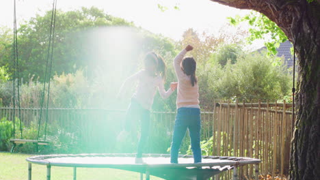 happy little girls jumping on a trampoline