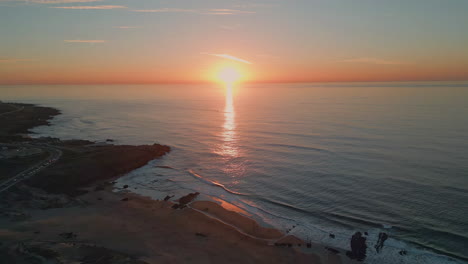 Sunrise sea rippling water beach aerial view. Golden dawn sky over dark ocean