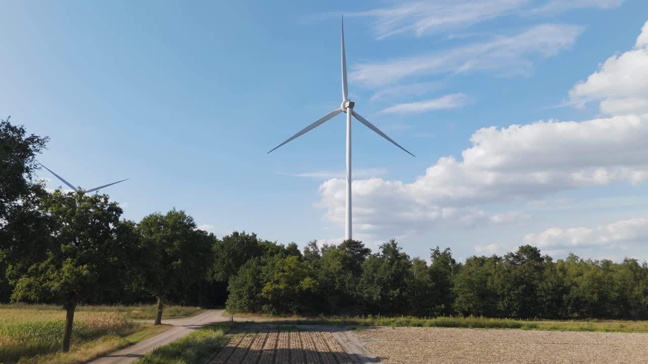 Drone footage of a large wind turbine spinning symbolizing renewable energy, sustainability, and climate change solutions for a greener future