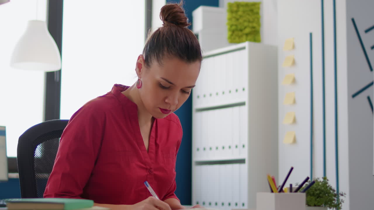 Company employee taking notes on charts documents