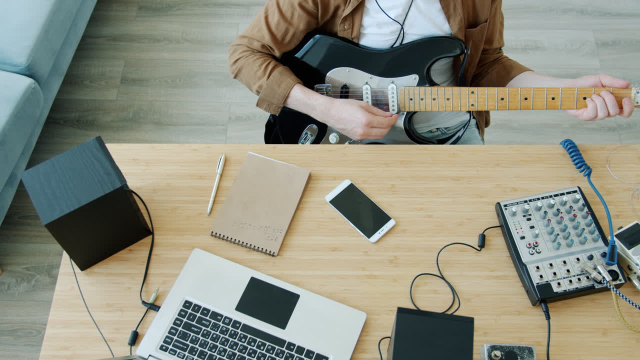 Musician Playing Guitar in Home Studio