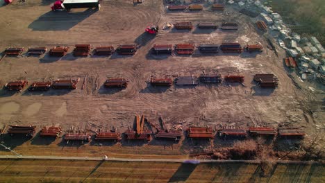 overview aerial of a forklift driver loading steel bars for a red semi conestoga truck driver