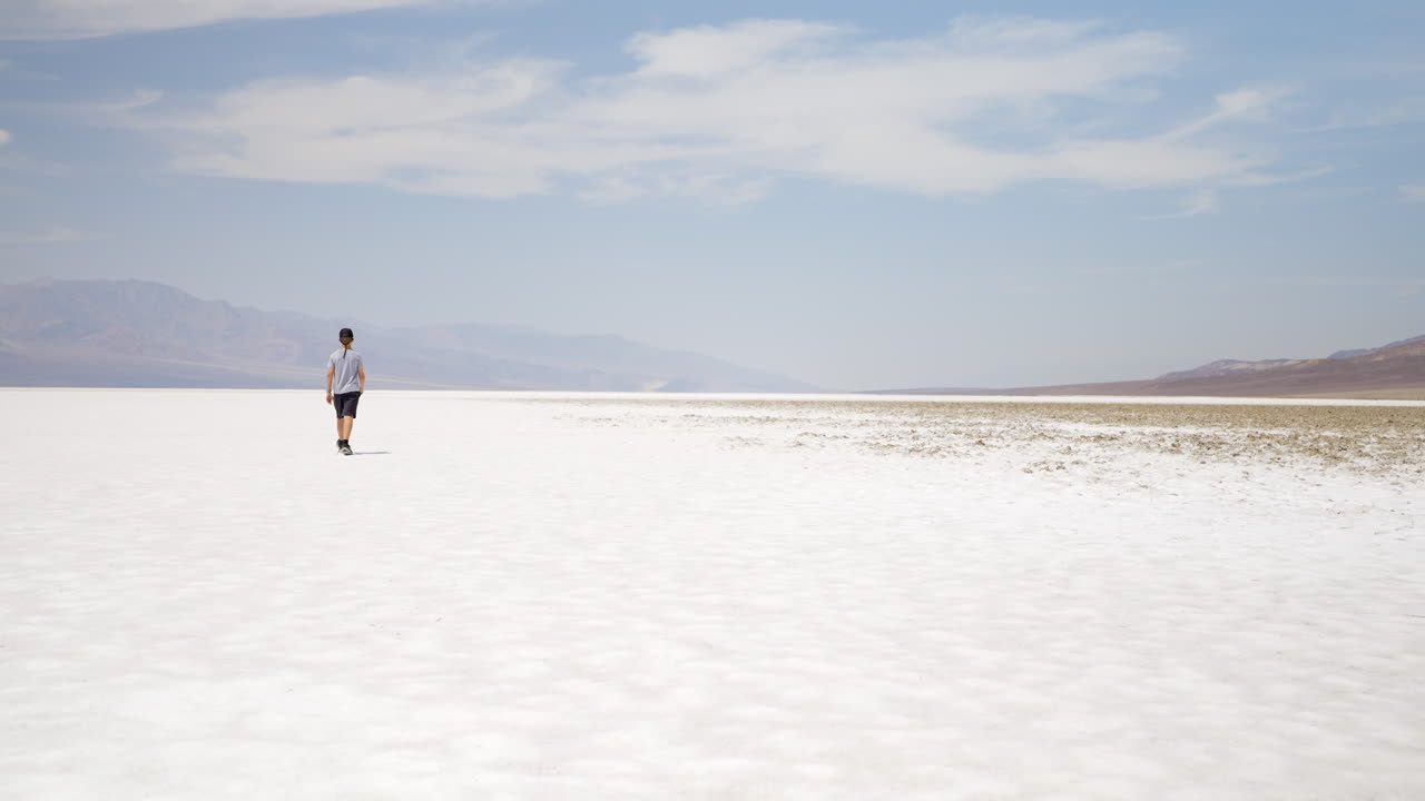 A Person Walking Across a Vast Salt Flat Landscape