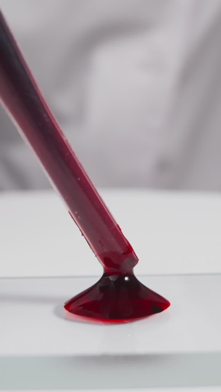 Specialist in white robe drips blood drop onto glass slide in laboratory slow motion. Probe lens footage of antivirus vaccine making macro view