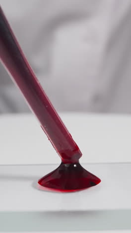 specialist in white robe drips blood drop onto glass slide in laboratory slow motion. probe lens footage of antivirus vaccine making macro view