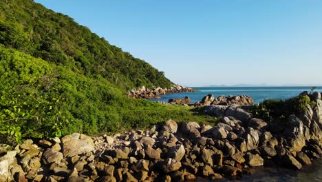 Drone-shot-of-rocks-at-the-bottom-of-a-mountains-bordering-the-sea-in-Brazil