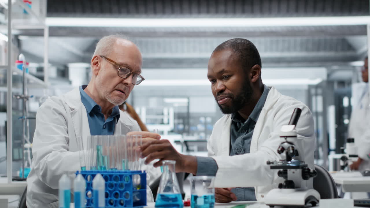 Teamworking lab researchers evaluating blue compound solution