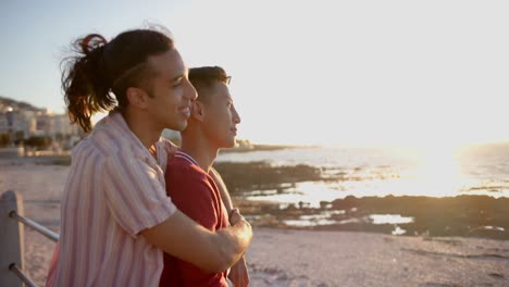 feliz pareja masculina gay diversa abrazándose en el paseo marítimo, cámara lenta