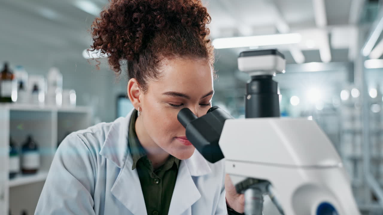 científica que usa un microscopio en un laboratorio