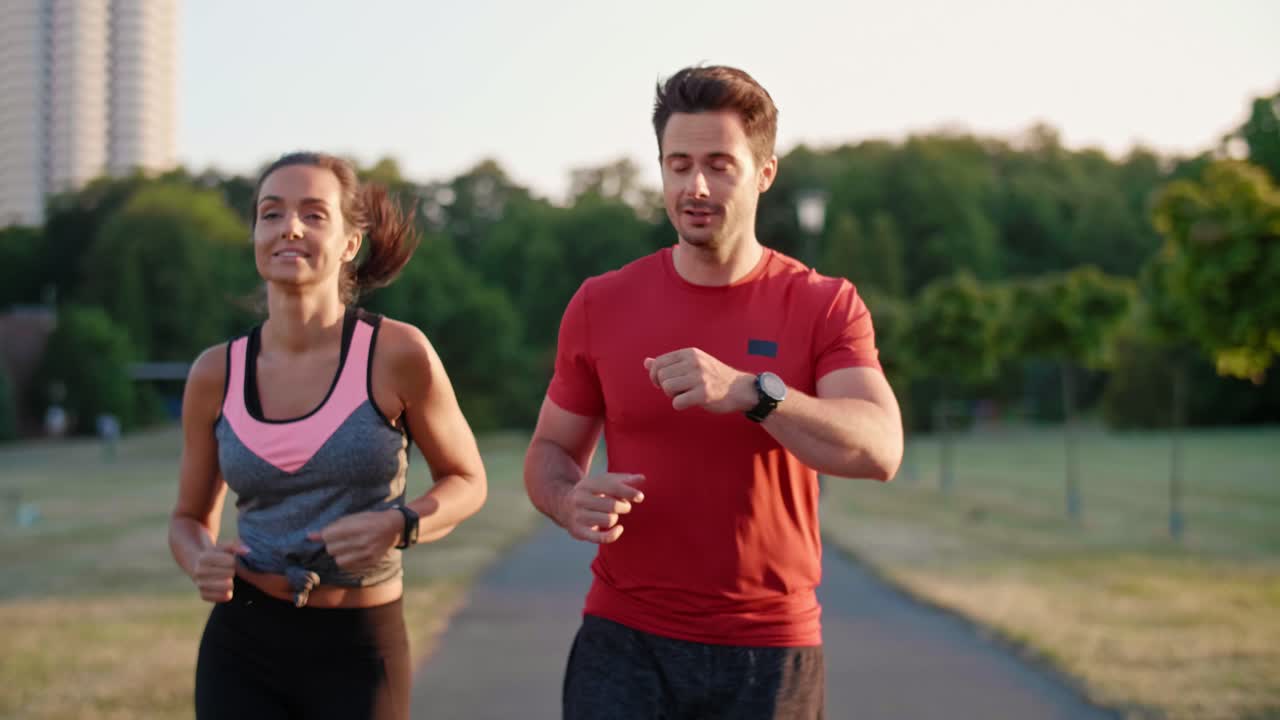 vista frontal de una joven pareja corriendo en el parque, katowice, polonia