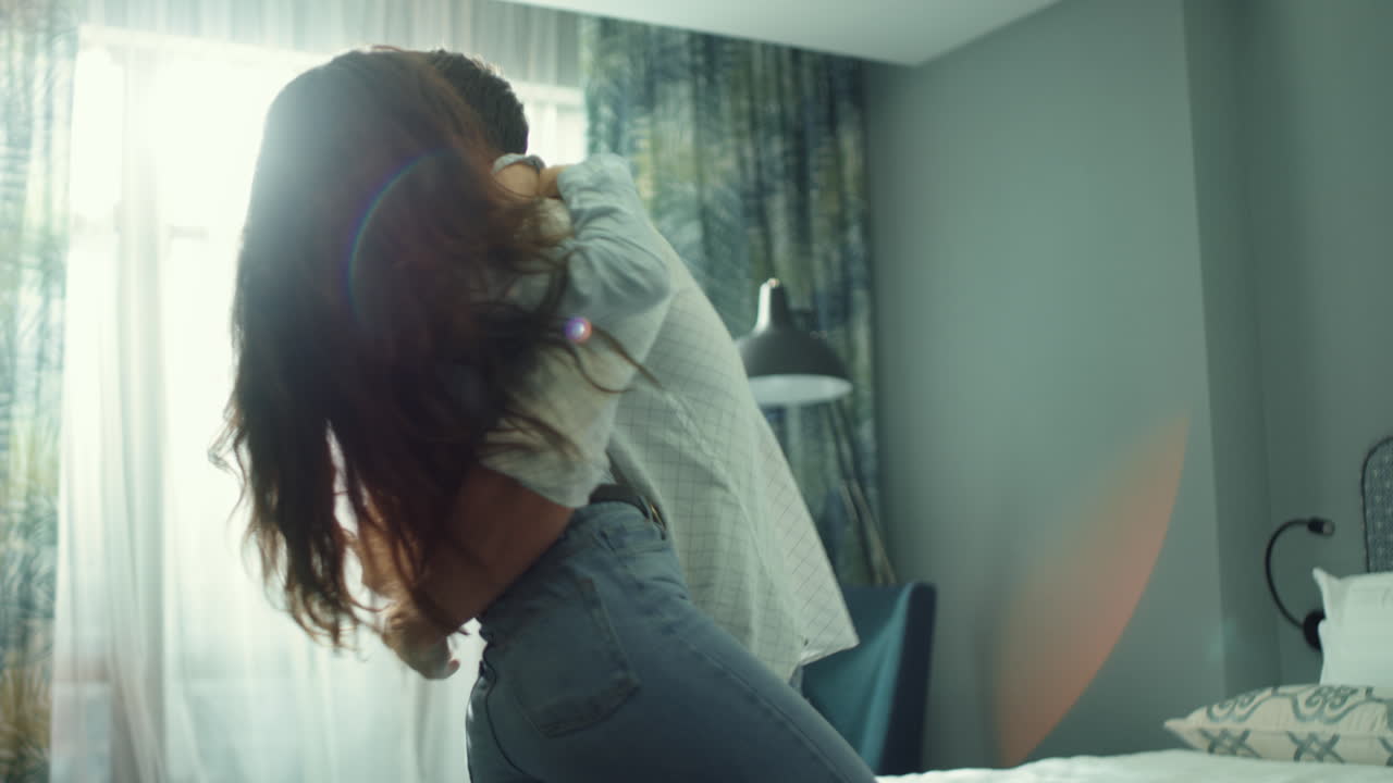 Smiling couple falling on bed in hotel room. Sensual couple meeting luxury suite