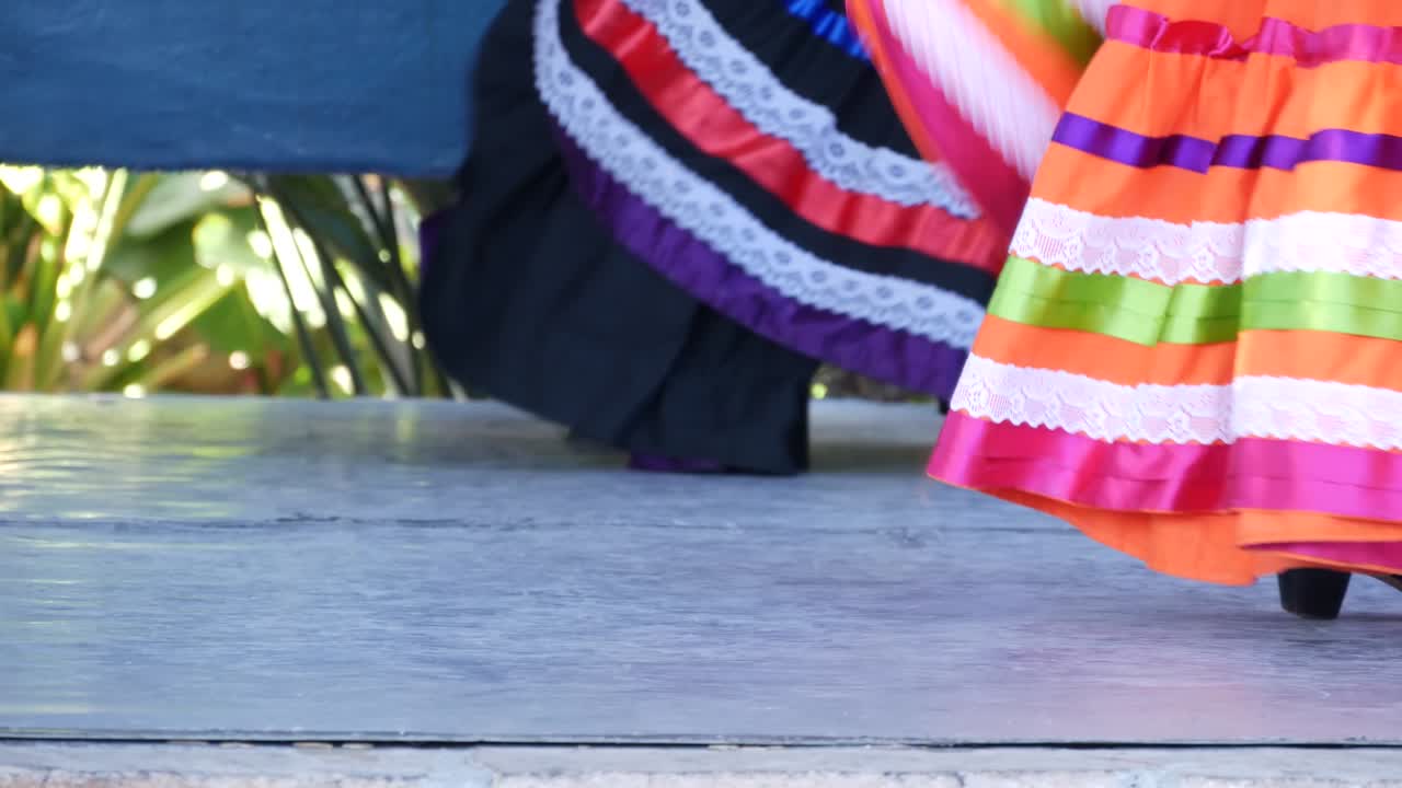 mujeres latinas con vestidos tradicionales coloridos bailando jarabe tapatio, danza nacional del sombrero popular mexicano. actuación callejera de ballet hispano femenino en faldas étnicas multicolores. niñas en trajes