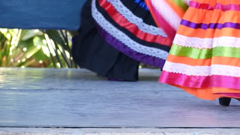 latino women in colourful traditional dresses dancing jarabe tapatio, mexican national folk hat dance. street performance of female hispanic ballet in multi colored ethnic skirts. girls in costumes