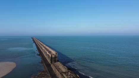 Aerial View of a Long Jetty Extending into the Calm Ocean