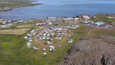 Tourist-camp-ground-filled-with-tents-and-campers-on-sunny-day-in-Borgarfjörður