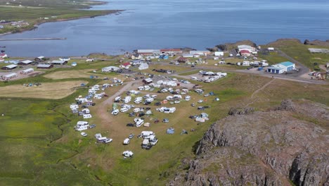 在borgarfjörður的阳光明<unk>的日子里, 游客露营地充满了帐<unk>和露营者