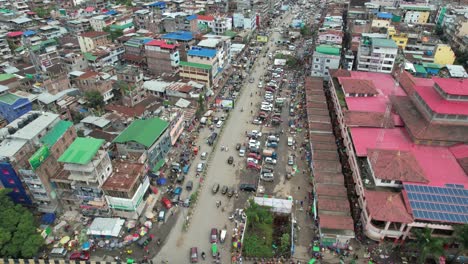 aerial drone shot of bridge surrounded by buildings, people, and cars