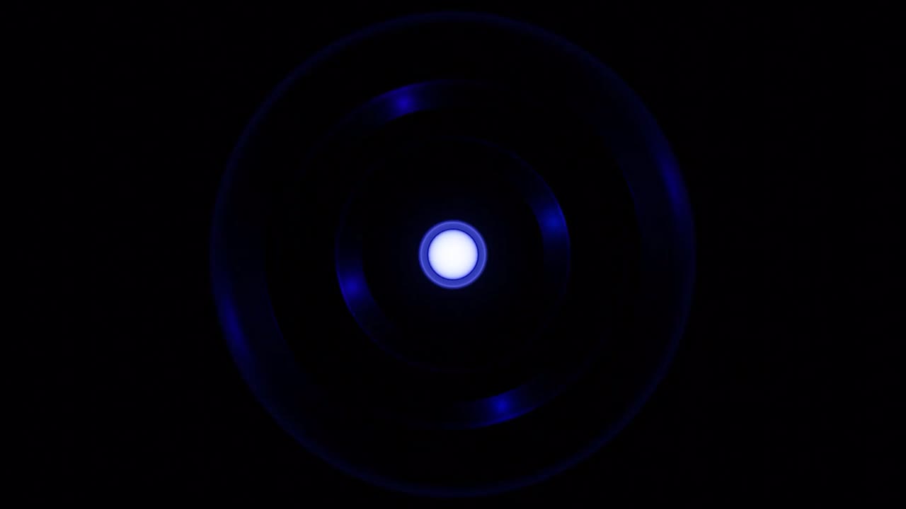 silueta de rueda de colores en un fondo negro, bucle sin costuras. diseño. círculo giratorio azul con luces alrededor del punto central