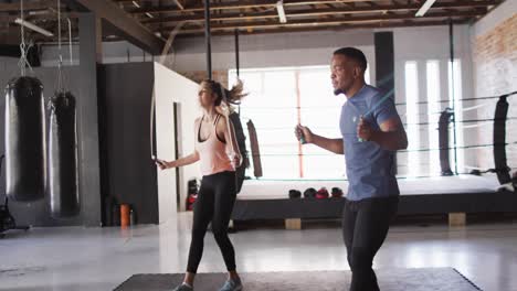 video de una mujer y un hombre diversos en forma saltando en la cuerda de salto en el gimnasio
