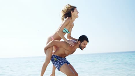 hombre dando paseo a caballo a la mujer en la playa