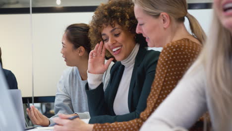 group of businesswomen collaborating in creative meeting around table in modern office