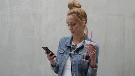 portrait stylish young woman using smartphone texting drinking juice enjoying carefree lifestyle digital communication on mobile device slow motion