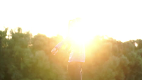 a girl in a pink jacket is preparing for a run warm up and listen to music in headphones through the phone