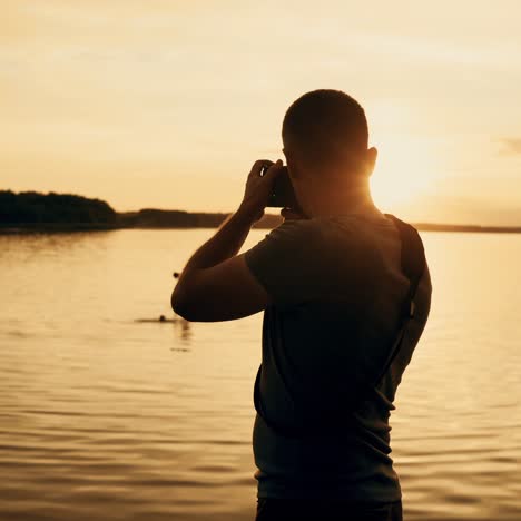 photographer silhouette at sunrise. beautiful summer sunset by the river