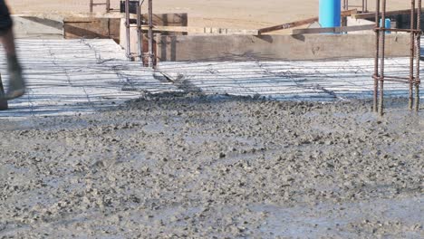 detail of worker adjusting concrete on floor of new residence