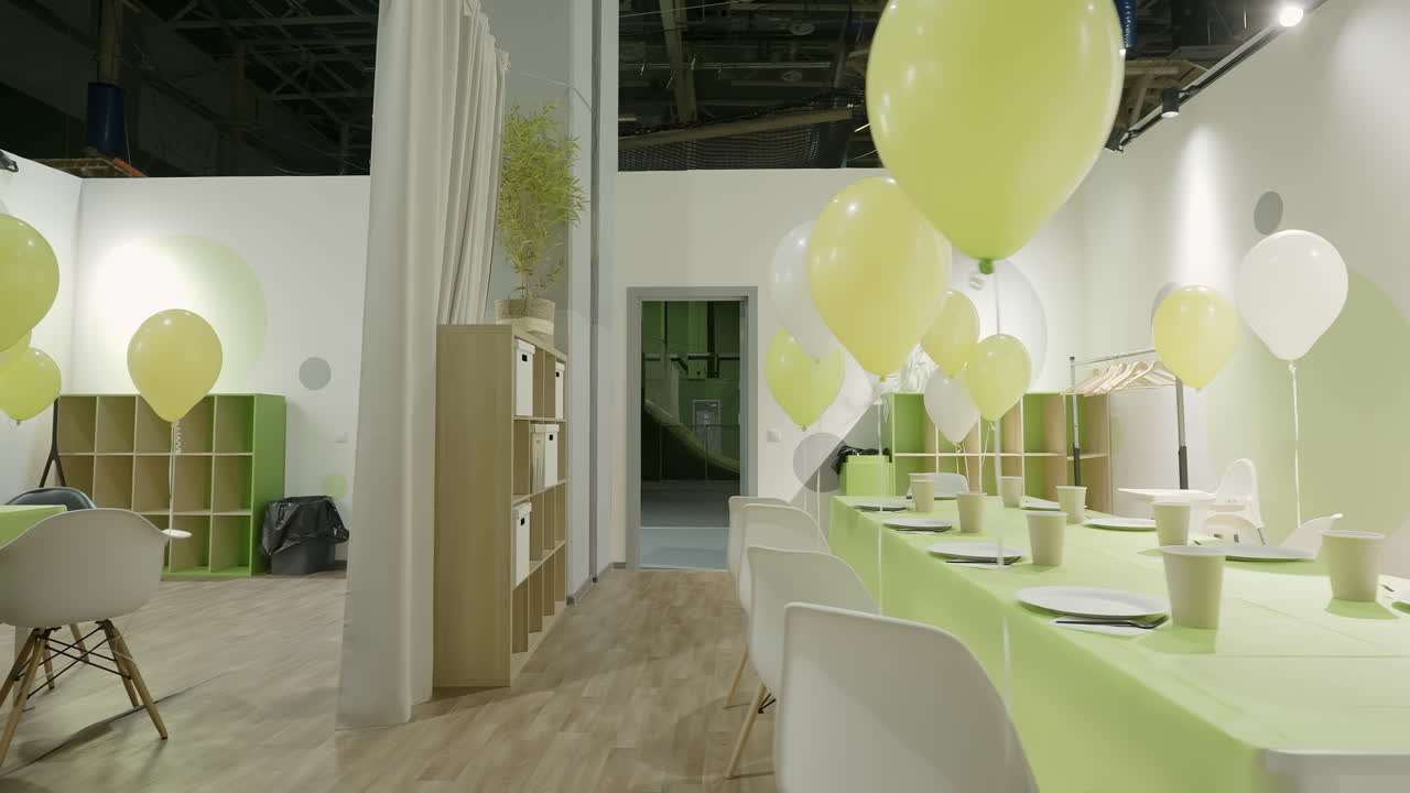 sala de fiestas de niños decorada con globos y configuraciones de mesa